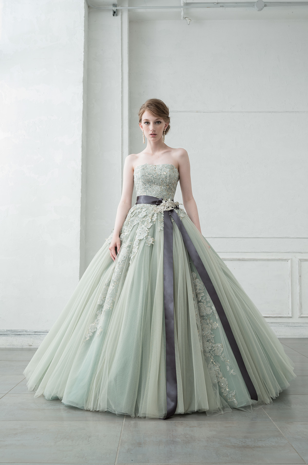 スモーキーグリーンの大人キレイなカラードレスです。 程よくアンニュイなカラーにビジューをあしらって、女性らしいエレガントなドレスラインも楽しめるテイストのオシャレなカラードレスです。 取り外し可能なショートジレはエレガントな総レース。上品でおとなしいイメージが特徴です。 シックなカラードレスなので同系色やグレー・ネイビーカラーのタキシードとの相性も抜群です！ シルエット：プリンセスライン 素材　　　：レース・チュール・ その他　　：レースジレ・リボンベルト２